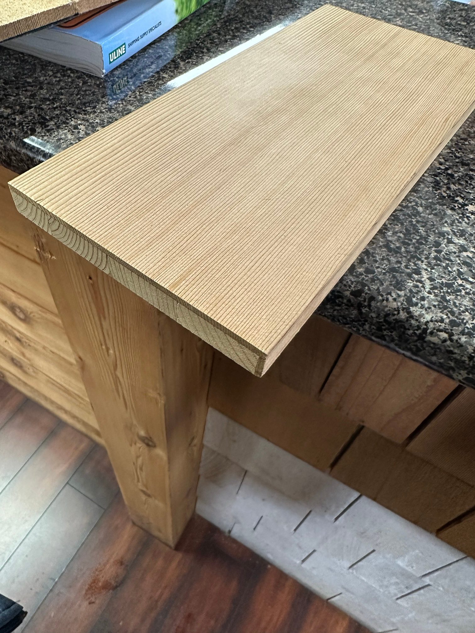 Engineered bevel siding sample on a counter showing the clear vertical-grain cedar face